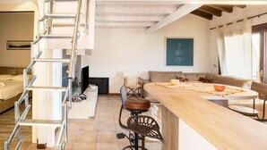 Een moderne keuken met een houten eiland, een inbouwfornuis en een ladder die naar een hoger niveau leidt.
