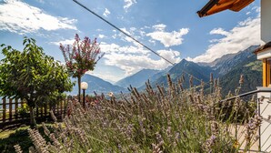 Un paisaje montañoso con una valla de madera, un farol y un edificio con techo inclinado.