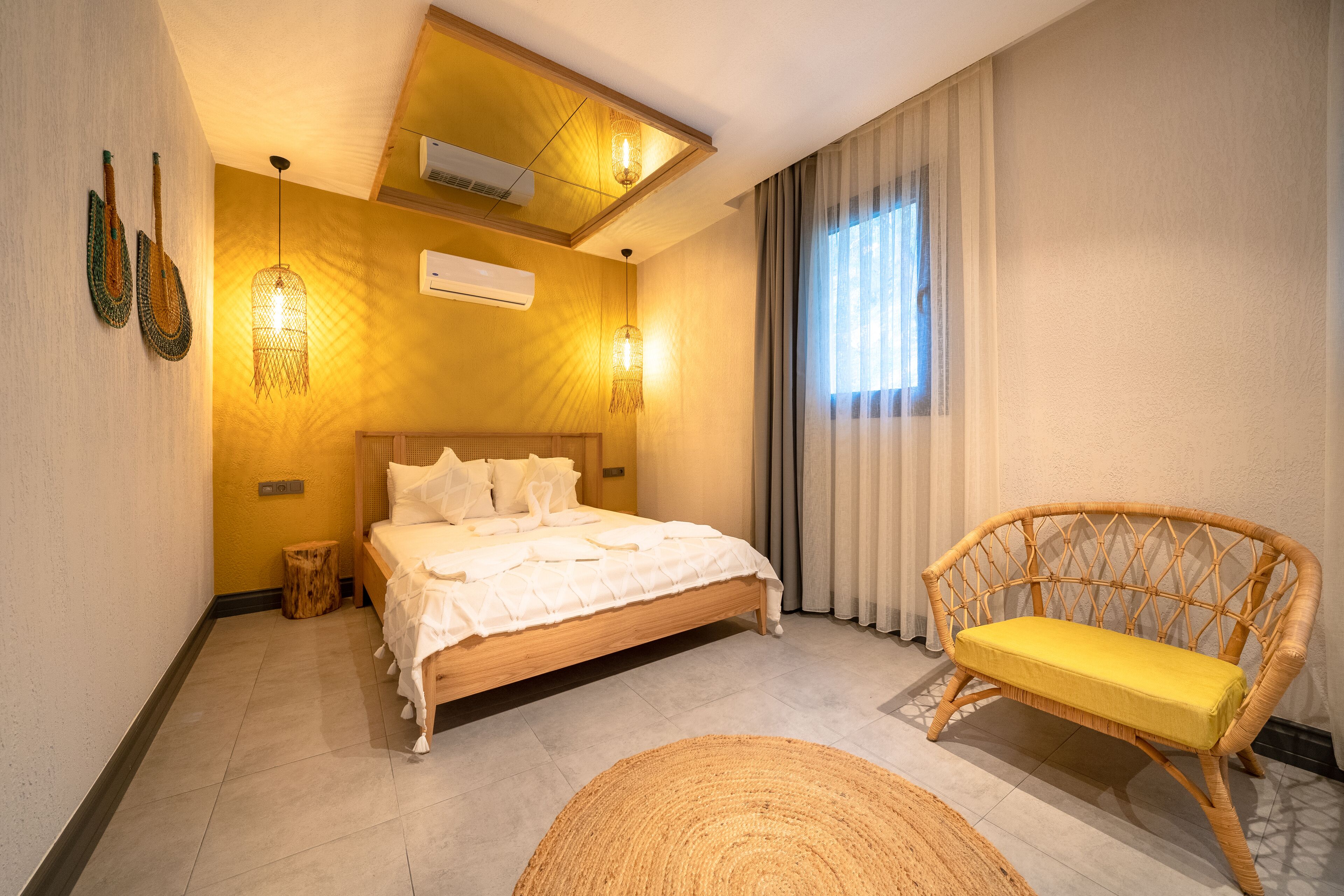 Une chambre avec un lit en bois, une chaise en osier et un tapis tissé.
