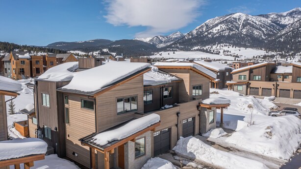 A modern residential area with snow-covered roofs and a mountain backdrop. - Luxury condo w/private hot tub & Lone Peak Views, minutes to Big Sky Resort - Copper John Getaway (Big Sky)