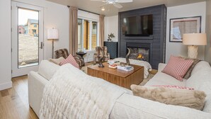 A living room with a sofa, coffee table, and fireplace. - Luxury condo w/private hot tub & Lone Peak Views, minutes to Big Sky Resort - Copper John Getaway (Big Sky)