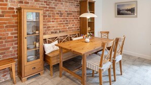 A wooden dining table with four chairs, a bench, and a cabinet with glass doors. - Mauersegler - Old Castle Brewery Apartments (Bad Wildungen)
