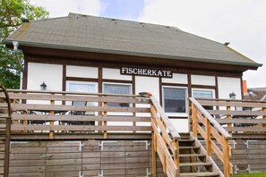 Un edificio con un letrero que dice 'FISCHERKATE' y una escalera de madera que lleva a una terraza.