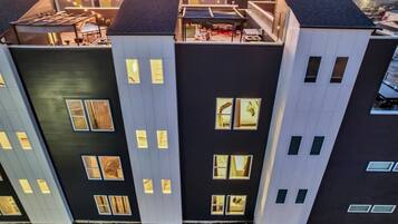 Un edificio moderno a più piani con tetto piatto, ampie finestre e una terrazza sul tetto.