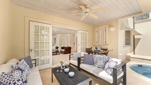 A spacious living area with a pool, a ceiling fan, and a dining area with outdoor seating. - Blue Horizon Battaleys Mews - Beautiful villa 5 minutes stroll to Mullins beach (Mullins)
