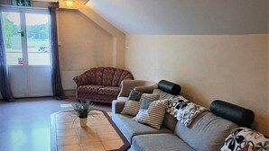 A modern living room with a sectional sofa, a coffee table, and a patterned rug. - Nipanhotellet (Solleftea)