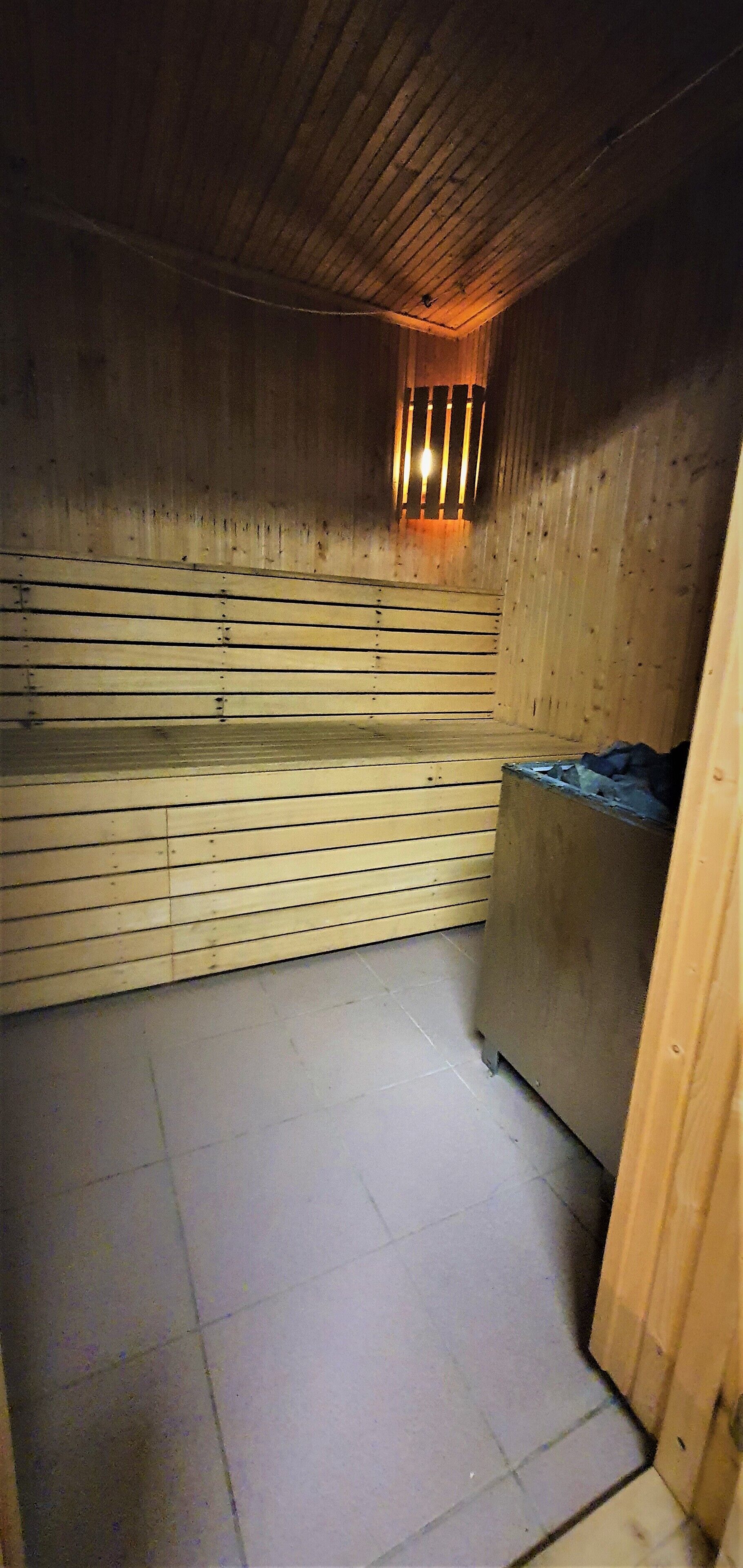 A wooden room with a sloped ceiling and a tiled floor.