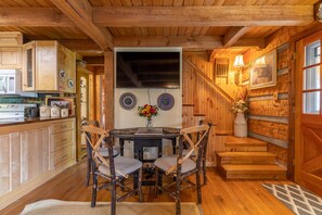 Un intérieur en bois comprenant une table à manger, des chaises et un escalier.