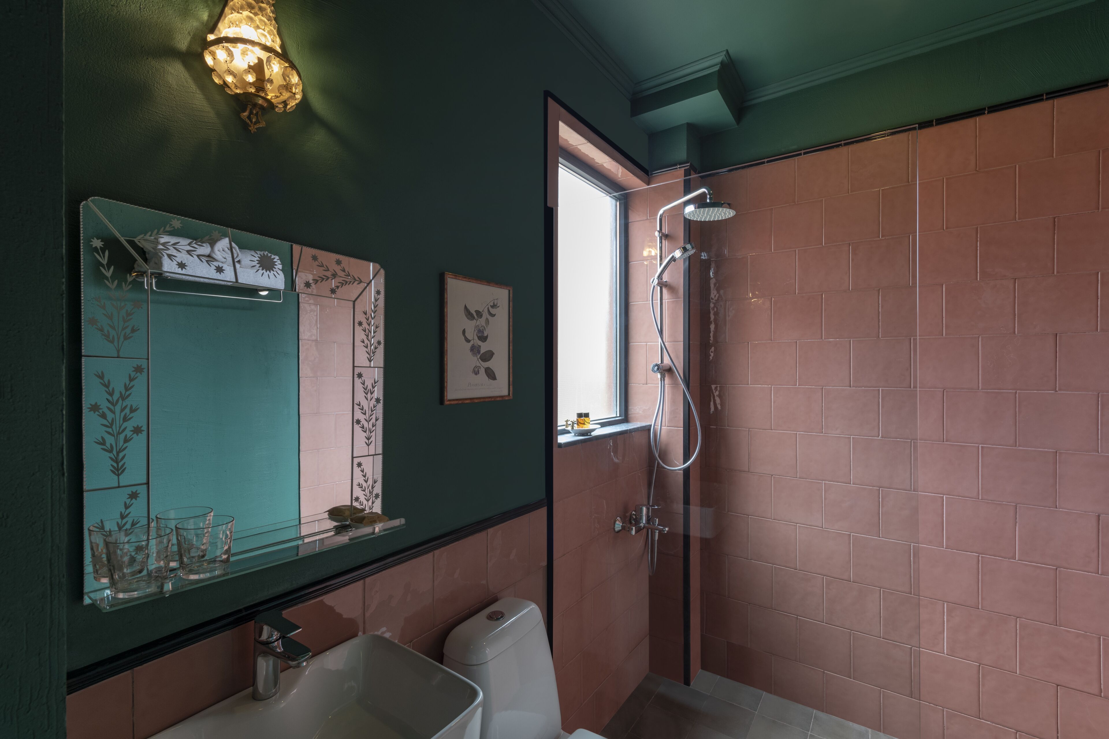 A bathroom with a glass shower enclosure, a sink, and a mirror.