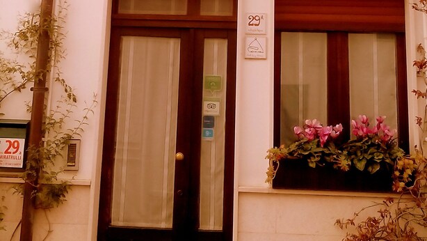 Ein zweistöckiges Gebäude mit Balkon, einer Tür und einem Fenster mit Blumenkasten.