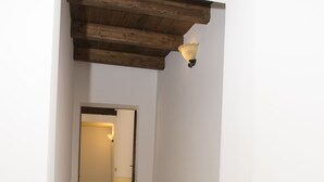 En smal gang med træloft og en lysarmatur på væggen.