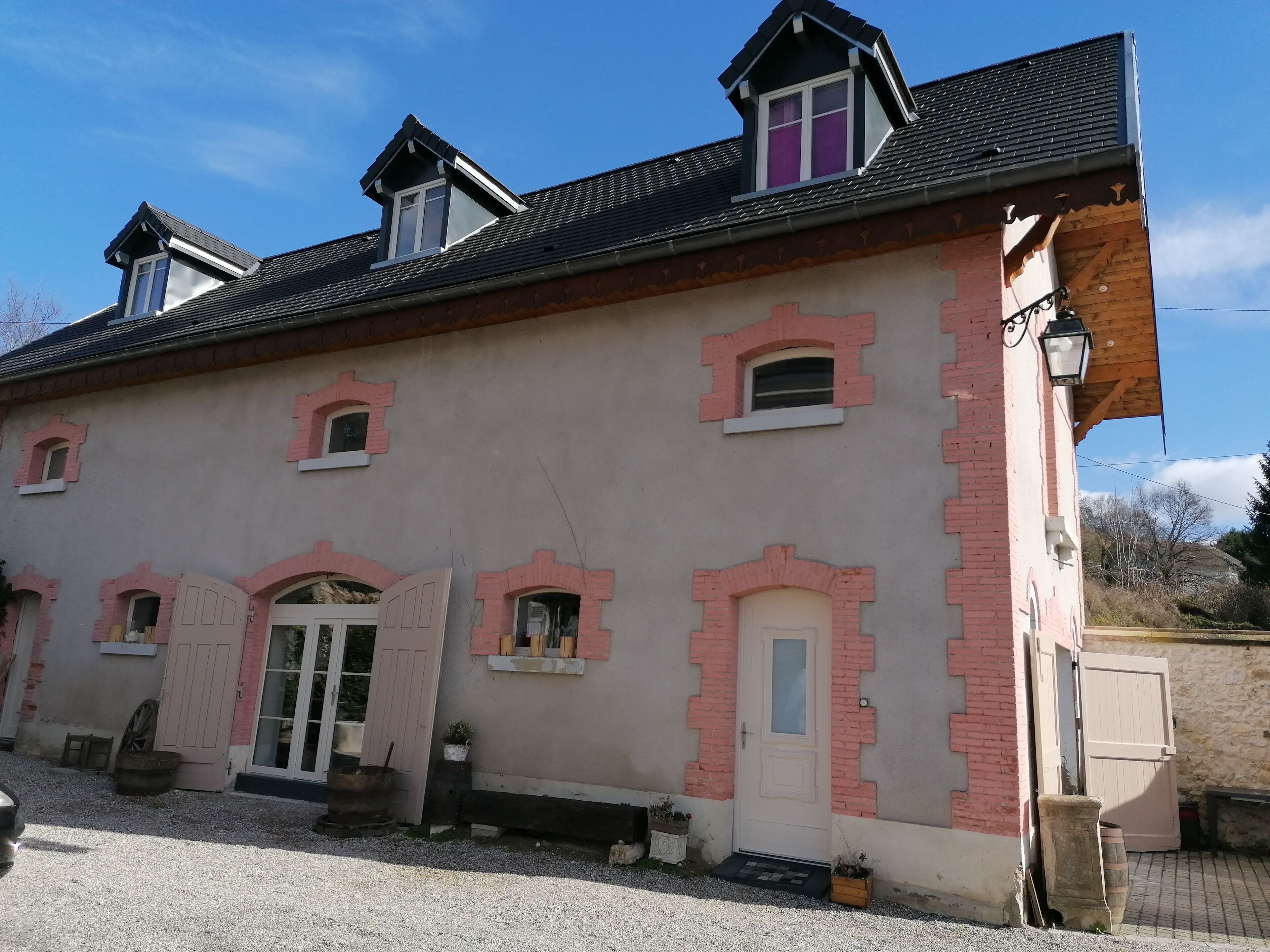 Un edificio con diverse finestre, una porta e un piccolo portico.