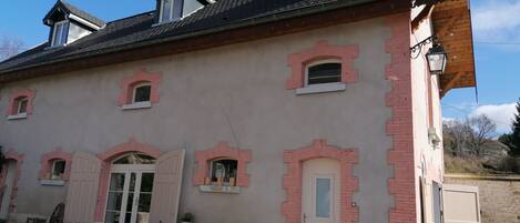 A building with multiple windows, a door, and a small porch area.