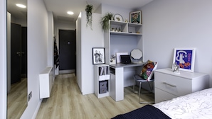 A modern bedroom with a desk, chair, and bed.