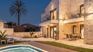 A modern house with a swimming pool, outdoor seating, and a palm tree. - Villa Vanka (Chania)