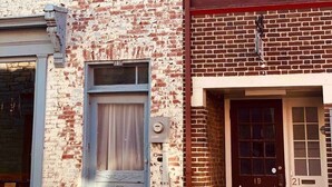 En toetages bygning med facade af mursten og en blanding af hvid og brun detaljering.