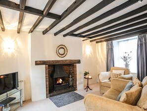 A living room with a fireplace, a television, and a sofa.