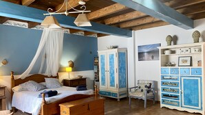 A bedroom with a wooden bed, a nightstand, a wardrobe, and a chair. - Casa Tabobo - 2 bedroom rural house with breathtaking sea views and a hot tub. (Tías)