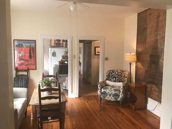 A dining area with a wooden table and chairs, a ceiling fan, and a view into the kitchen. - Pretty Little Apt by the Train II (Winchester)