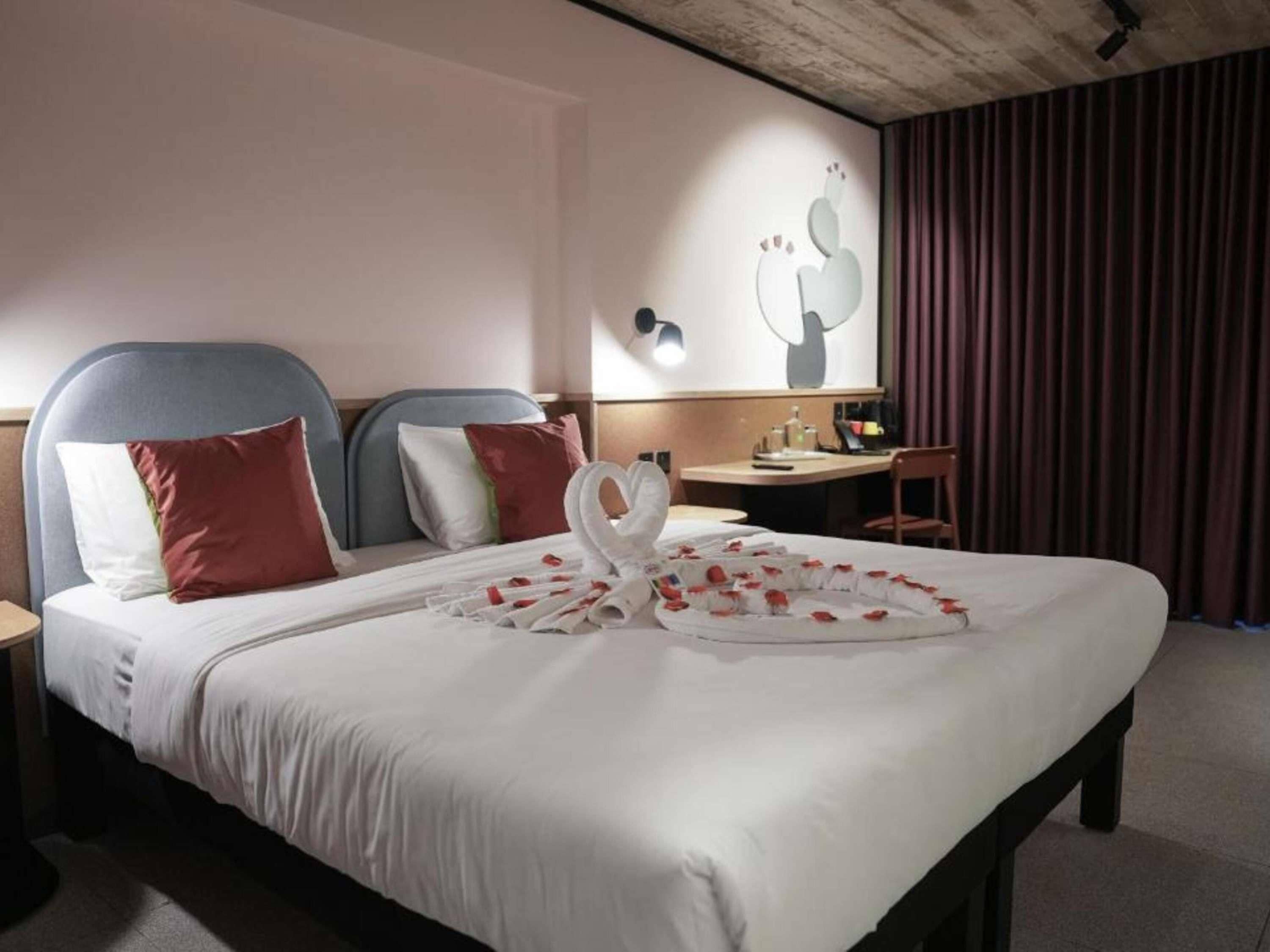 Una habitación de hotel con una cama, un escritorio y una cortina.