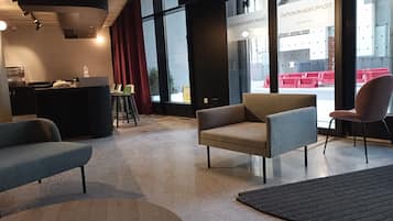 Un interior moderno con zona de estar, cocina y ventanas amplias.