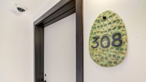 Una porta con una targa che mostra il numero 308 su un muro strutturato.