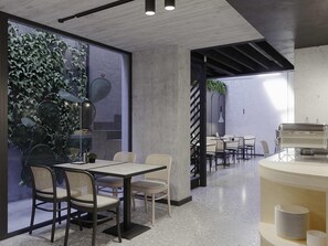 Un comedor moderno con techo de concreto, paredes de vidrio y mobiliario de metal y mimbre.