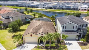 A residential area with houses, a body of water, and a well-maintained lawn. - Marvel Villa - 20 minutes to Disney (Davenport)