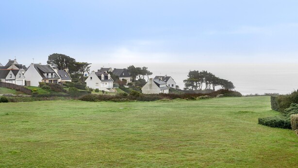 A residential area with houses on a hillside, a grassy field in the foreground, and a clear sky. - 300m from the beach, 2 adults - 2 children (Saint-Gildas-de-Rhuys)