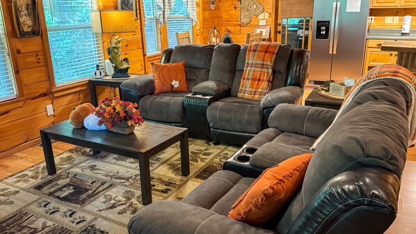 Ein gemütliches Wohnzimmer mit einer Eckcouch, einem Couchtisch und einem Teppich.