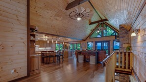 A spacious kitchen with wooden cabinets, a central island, and bar stools. - Happy Hour Heights – Blue Ridge, Ga. (Blue Ridge)