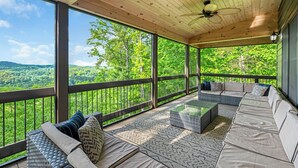 A covered outdoor seating area with a view of a forest and hills. - Happy Hour Heights – Blue Ridge, Ga. (Blue Ridge)