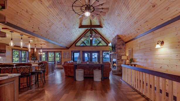 A spacious wooden interior with a high ceiling, a central seating area, and large windows providing natural light. - Happy Hour Heights – Blue Ridge, Ga. (Blue Ridge)