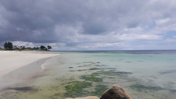 A beach with clear turquoise water, a sandy shore, and a cloudy sky. - Self-contained apartment in Breton house (Loctudy)