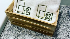 A wooden box with two white towels, each with embroidered text "LAPA CITY LOFT". - Oporto City Center Apartment with terrace (Porto)