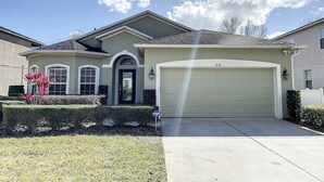 A two-story house with a garage, a front door, and a driveway. - Palace Retreat - Private Pool/Spa & 24/7 Support (Davenport)