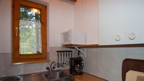 A kitchen with a sink, stove, microwave, and various utensils. - Aparthotel Buchauer.Tirol in a natural paradise (Vorderthiersee)