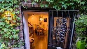 A narrow entrance with a wooden door leading into a dining area. - One Such Boston Gem w Pvt Garden (Boston)