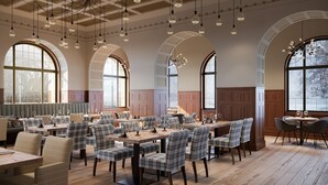 A restaurant with high arched windows, wooden paneling, and modern pendant lighting. - ALPINE INN Davos (Davos)
