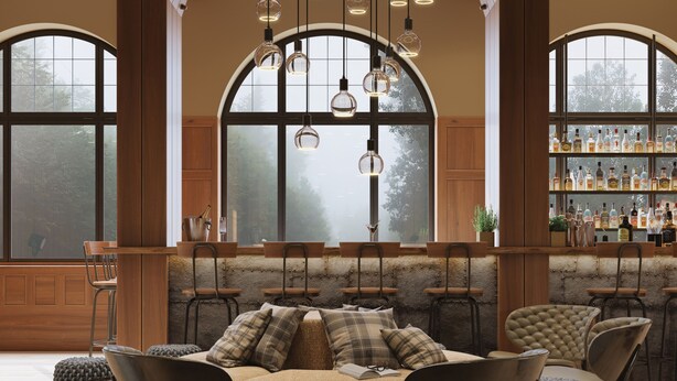 A cozy seating area with a bar in the background, featuring a large arched window and hanging pendant lights. - ALPINE INN Davos (Davos)