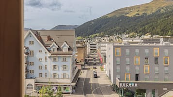 Vista de una calle con edificios, una carretera y una montaña al fondo.