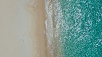 Enjoy a serene beach experience with gentle waves lapping at the shore.