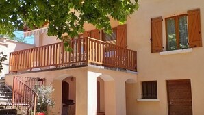 Ein zweistöckiges Gebäude mit Balkon, Treppe und einer Tür.