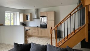A modern kitchen with light wood cabinets, a central island, and a built-in oven. - La Colombière - SAINT-SYMPHORIEN-D'OZON (Saint-Symphorien-d'Ozon)