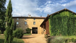 A rustic stone building with a gravel path leading to a wooden door.