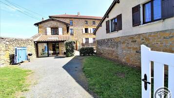 Enter a charming property through a gravel path, leading to a welcoming front door and a garden area.