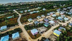 An aerial view of a residential area with houses, roads, and a coastline. - The Rookery Iii 6015 3 Bedroom Cottage by RedAwning (Gulf Shores)