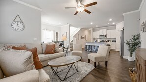 A modern living room with a sofa, coffee table, and a ceiling fan. - Pet-Friendly 3BR Home Near I-85 and River Trails (Norcross)