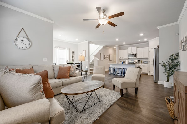 A modern living room with a sofa, coffee table, and a ceiling fan.