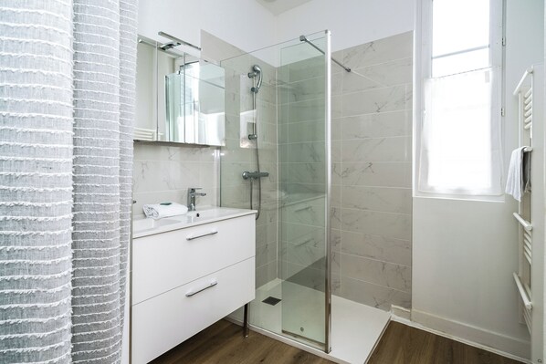 Regadera, secadora de cabello, toallas, papel de baño 